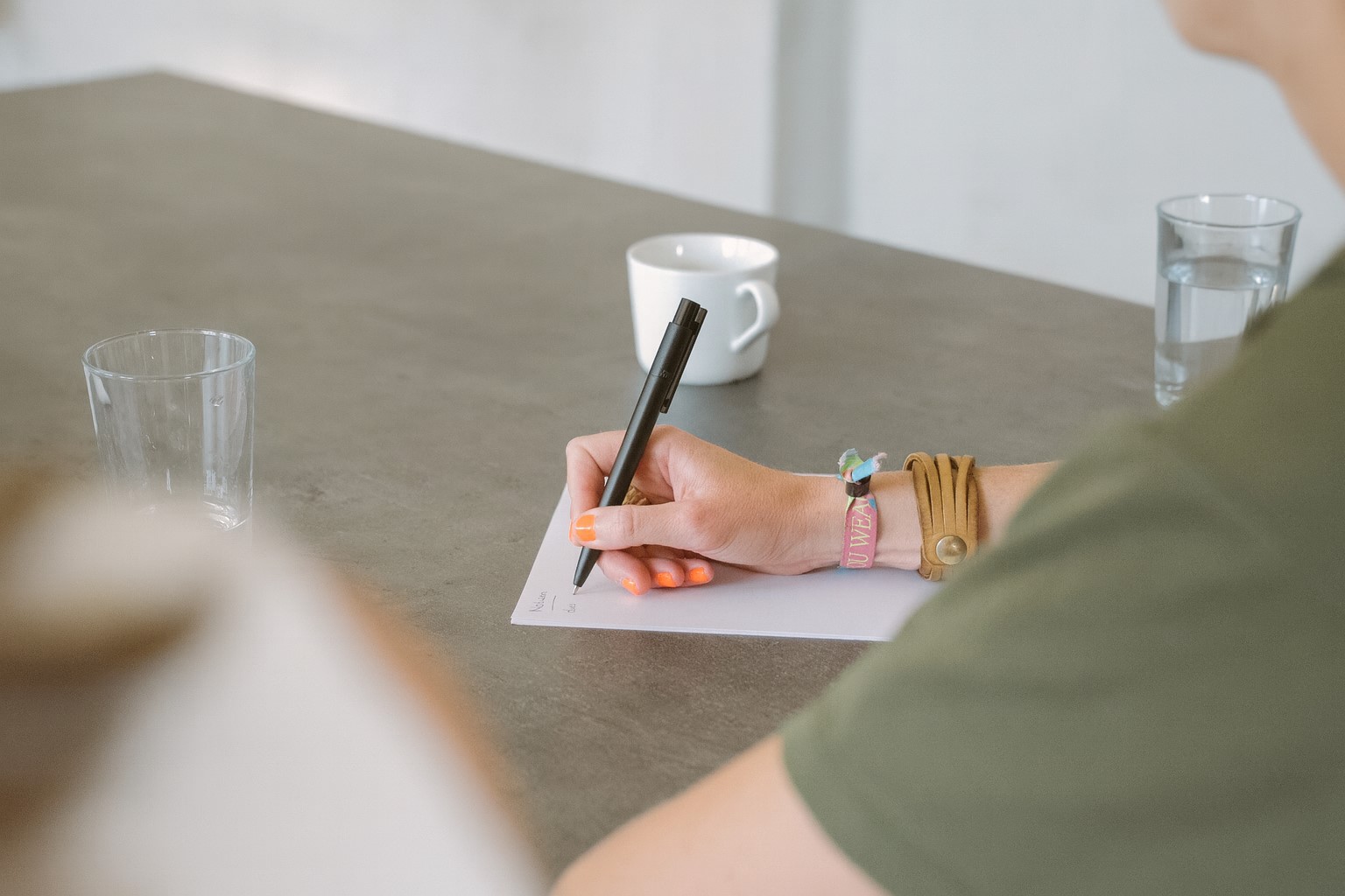 selbstfuehrung Person schreibt auf Zettel