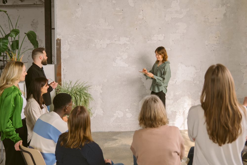Frau präsentiert vor einer Gruppe in einem Workshop zum Thema Führungskräfteentwicklung