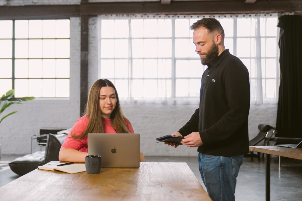 Zwei Personen arbeiten gemeinsam an einem Laptop